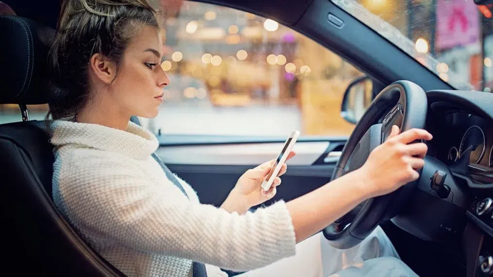 Person watching phone while driving